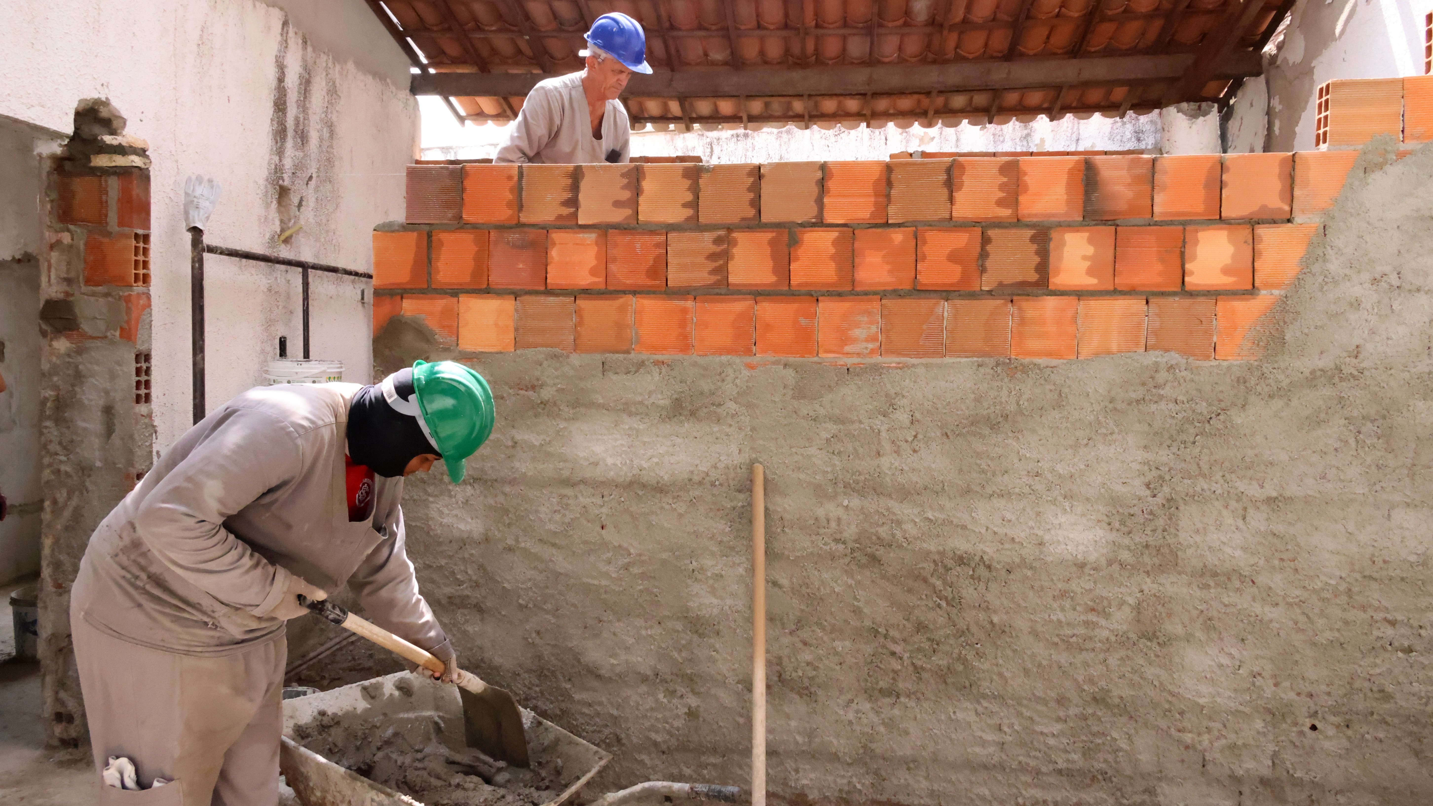 operários erguendo um muro na obra do creas